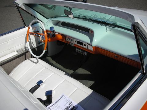 1998 Ford Crown Victoria - The interior of a classic convertible shows off its distinctive orange and white steering wheel and dashboard details.