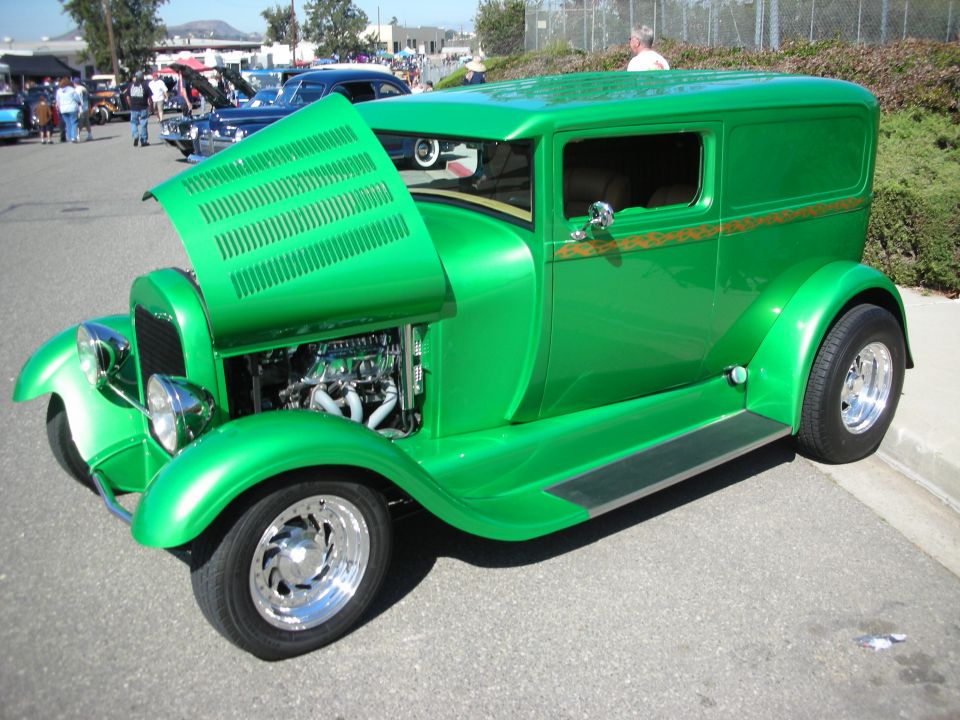 Green hot rod sedan delivery with louvered hood open at an outdoor car show