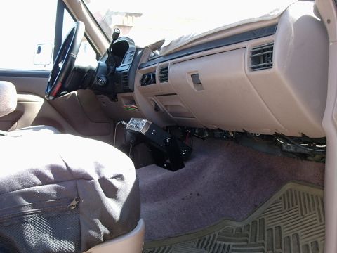 1996 Ford Bronco - Passenger-side interior of a 1992-96 Ford Bronco/F-Series with the tan dash partly disassembled: the glovebox door and lower trim are off,…