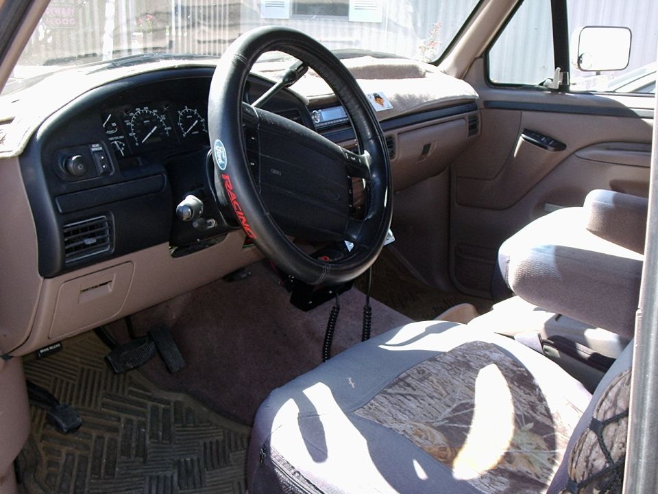 Tan truck interior with Ford Racing steering wheel cover and camo seat covers