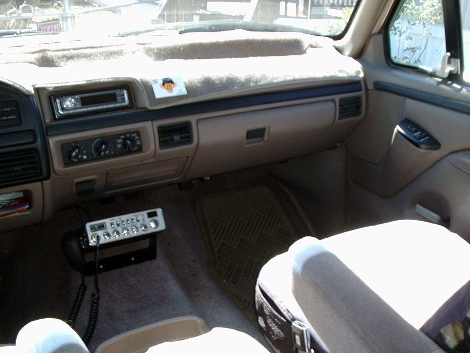 Tan Ford OBS dashboard with CD head unit and chrome CB radio on center bracket