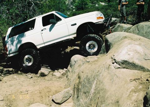 1995 Ford Bronco - A white 1995 Ford Bronco navigates a challenging rocky off-road course.