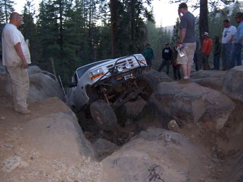 1995 Ford Bronco - This modified 1995 Ford Bronco tackles a challenging rocky obstacle course with spectators watching.