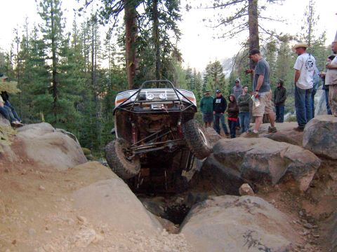 1995 Ford Bronco - Modified 1995 Ford Bronco navigating a difficult rocky trail with spectators watching.
