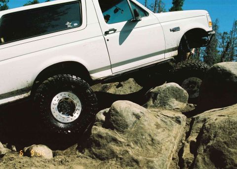 1995 Ford Bronco - White 1992 Ford Bronco tackles a rocky trail, demonstrating its off-road capabilities.