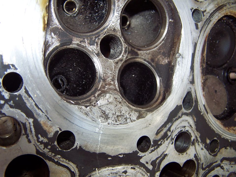 Close-up of a corroded engine cylinder head combustion chamber