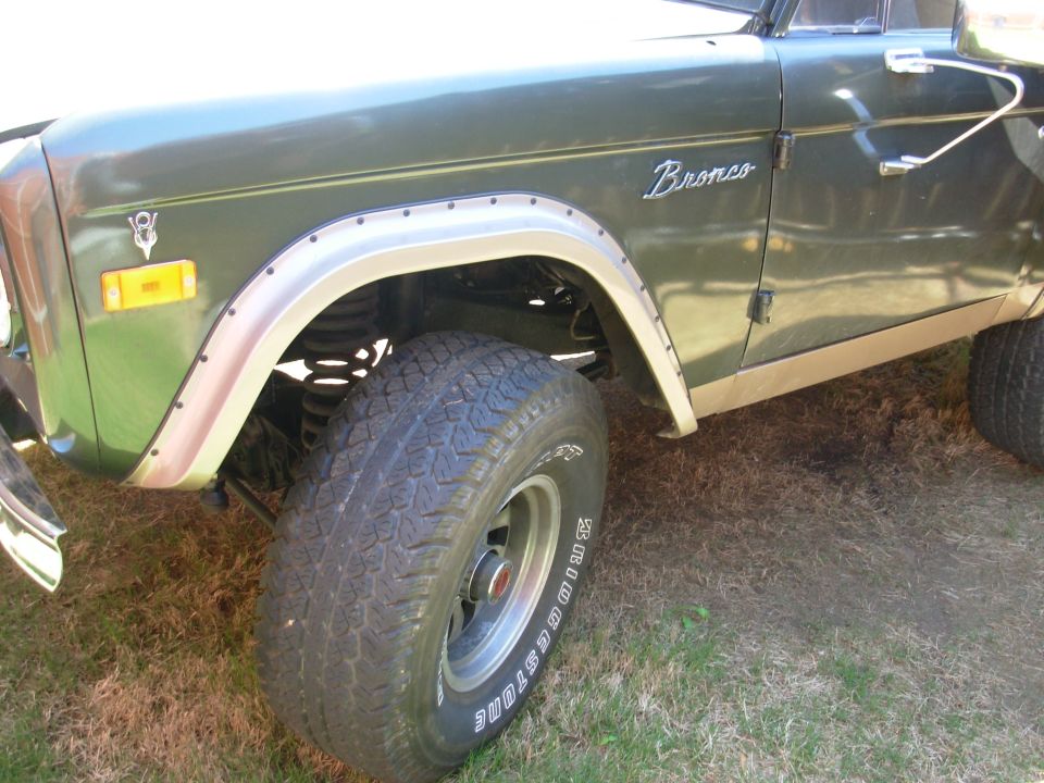 Green early Ford Bronco fender and tires with Bronco emblem