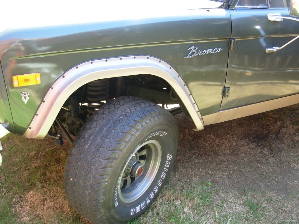 Front quarter of green Ford Bronco with Bronco badge and Bridgestone tire