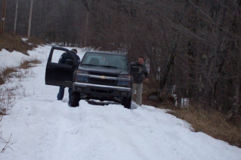 2000 Chevrolet Tahoe - A dark-colored Chevrolet Colorado pickup truck is parked on a snow-covered road with two men nearby.