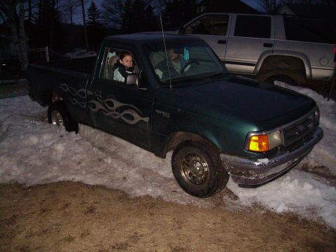 2000 Chevrolet Tahoe - A green Ford Ranger pickup truck is stuck in the snow with two people inside.