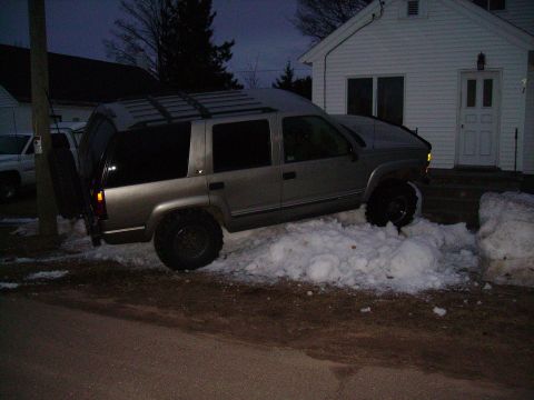 2000 Chevrolet Tahoe - This silver SUV, likely a 1995 model, is stuck in a snowdrift next to a house.