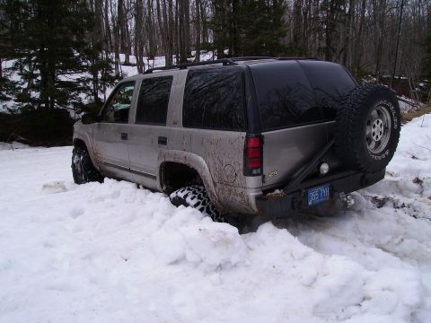 2000 Chevrolet Tahoe - 2000 Chevrolet Tahoe stuck in snow with spare tire on rear bumper.