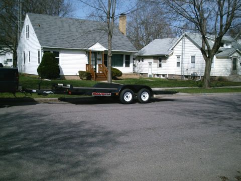 2001 Dodge 2500 - A tandem axle trailer is parked on a residential street.