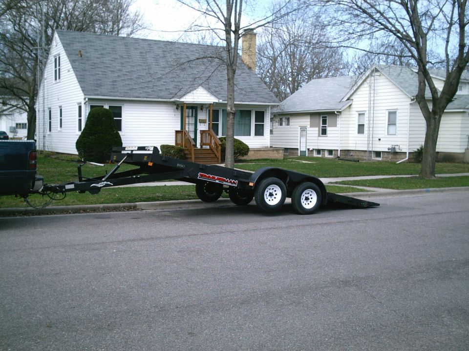Black tandem axle trailer parked on street