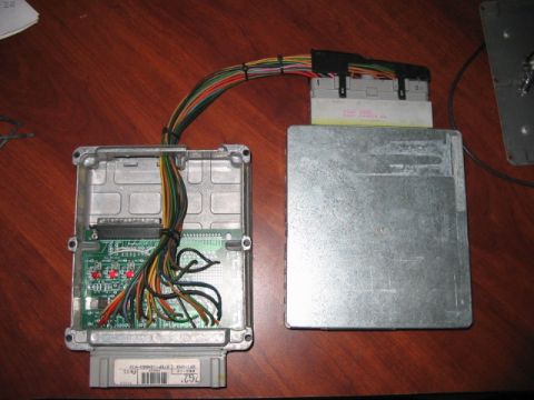 1991 Ford Bronco - An engine control unit is shown with its wiring harness and connectors, suggesting a component for a vehicle.