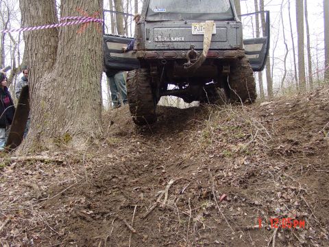 1995 Dodge 1500 - A Suzuki Samurai navigates a challenging muddy incline with onlookers nearby.