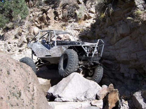 1986 Ford Bronco - This heavily modified buggy is shown crawling over large rocks in a canyon.