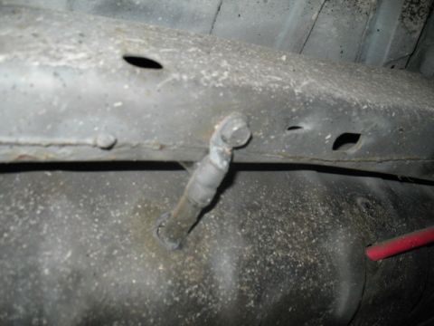 1985 Ford LTD Crown Victoria - Underbody view of a vehicle, focusing on a fuel line connection to the frame.