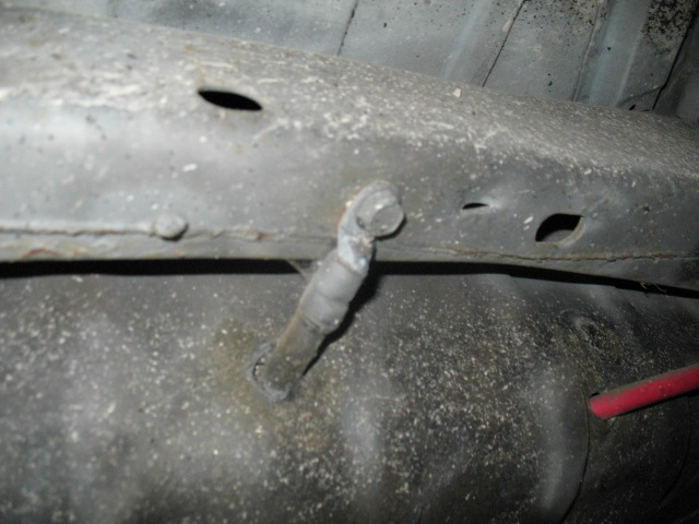 Close-up of a vehicle's underbody showing a fuel line attached to the frame