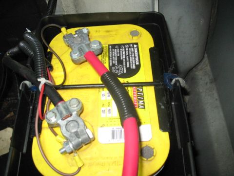 1985 Ford LTD Crown Victoria - Close-up of a car battery with visible terminals and wiring.