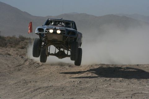 1996 Ford Bronco - A modified off-road truck soars through the air during a desert race.