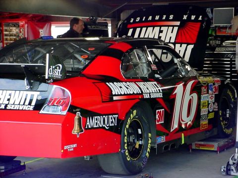 1993 Ford Mustang - Race car #16 with Jackson Hewitt Tax Service livery is parked in the garage, ready for service.