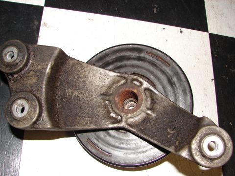 1992 Ford Taurus - Close-up of an automotive part, likely a pulley system component, on a checkered surface.