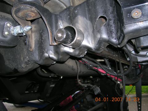 1996 Ford Bronco - Close-up view of vehicle undercarriage components, including a splined shaft and wiring harness.