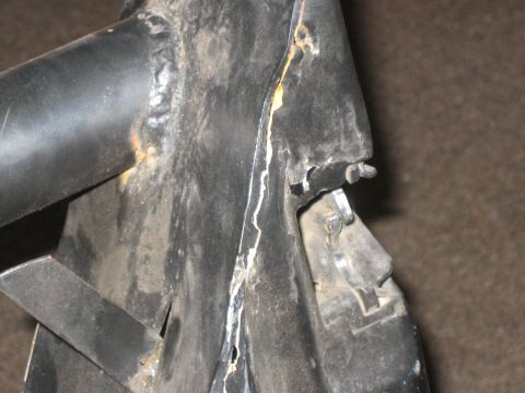 1995 Ford Bronco - Detail of a black metal component, showing welds and signs of wear.