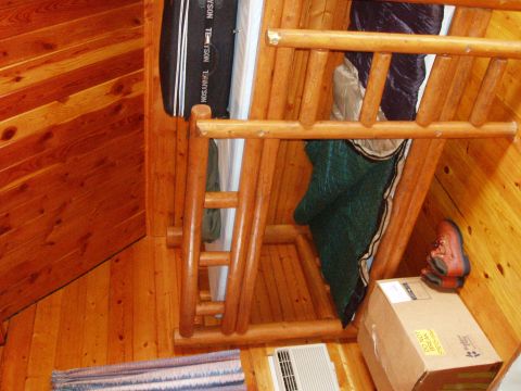 1978 Ford Bronco - Interior view of a rustic wooden cabin, showing bunk beds, sleeping bags, and personal items.