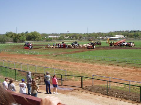 1978 Ford Bronco - Various vehicles and machinery are present on a dirt track, with a crowd observing the activity.