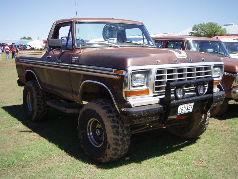 1978 Ford Bronco - A lifted 1978 Ford Bronco with a brown paint job and chrome trim is parked outdoors next to another vehicle.