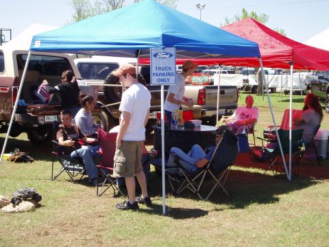 1978 Ford Bronco - An outdoor gathering with tents and parked vehicles suggests a car show or event.