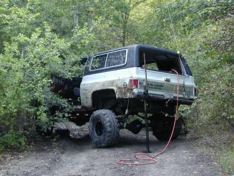 1996 Ford Bronco - This 1973 Chevrolet K5 Blazer is stuck in the mud, with 'ROLL & RECOVERY' visible on its tailgate.