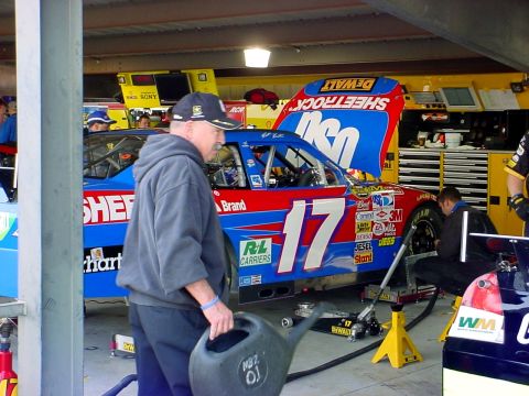 1993 Ford Mustang - A race car with the number 17 is being serviced in a garage bay, with crew members attending to it.