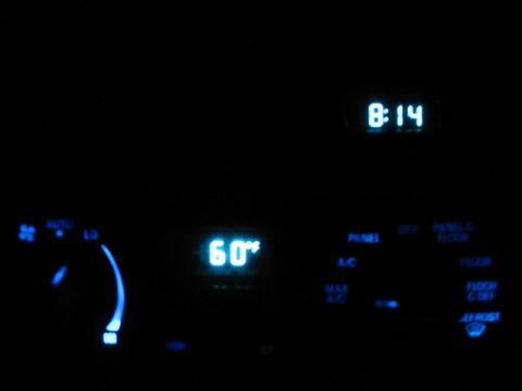 1995 Ford Thunderbird - The illuminated dashboard displays the time and temperature, along with various climate control settings.