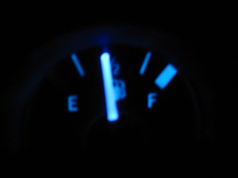 1995 Ford Thunderbird - Close-up of a car's fuel gauge, illuminated in blue, indicating the tank is almost full.