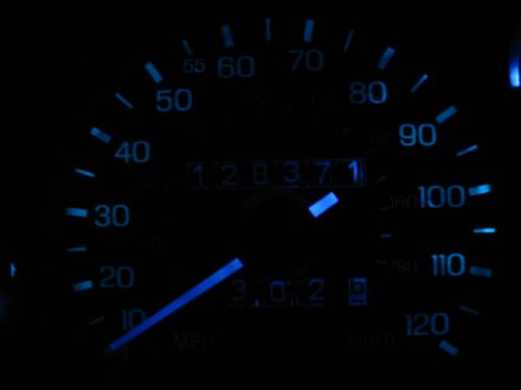 1995 Ford Thunderbird - Close-up of a car's illuminated dashboard gauges, displaying mileage and speed.
