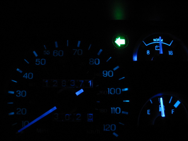 Dashboard gauges with blue illumination, showing odometer reading 128371