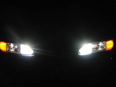 1995 Ford Thunderbird - Headlights with amber turn signals are illuminated against a dark background.