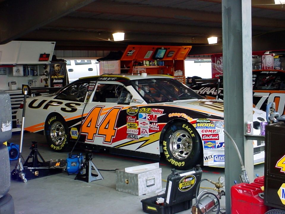 Race car with number 44 and UPS logo in a garage