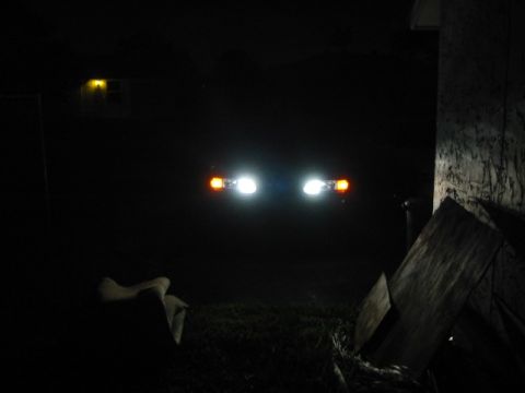 1995 Ford Thunderbird - The front of a 1995 Ford Thunderbird is visible at night with its headlights and turn signals on.