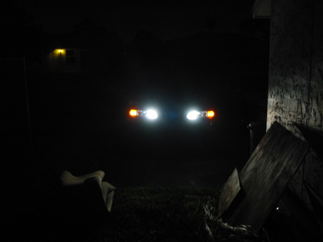 1995 Ford Thunderbird headlights and amber turn signals illuminated at night