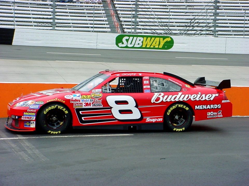 Red No. 8 Budweiser stock car on track in front of a Subway sign