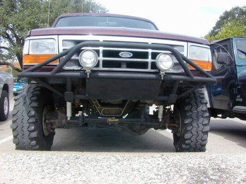 1996 Ford Bronco - Modified 1992-1996 Ford Bronco front end with custom bumper and lights. Another vehicle is parked nearby.