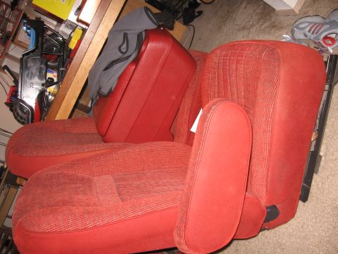 1990 Ford Bronco - Red cloth bucket seats and center console removed from a vehicle.