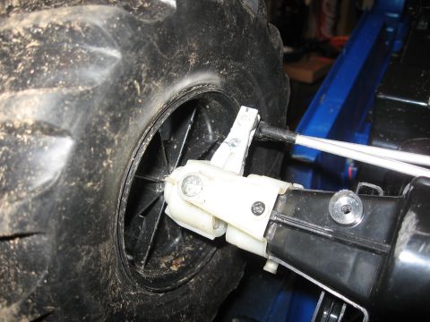 1990 Ford Bronco - Detail of a suspension part on a remote control vehicle, showing plastic components and a large tire.