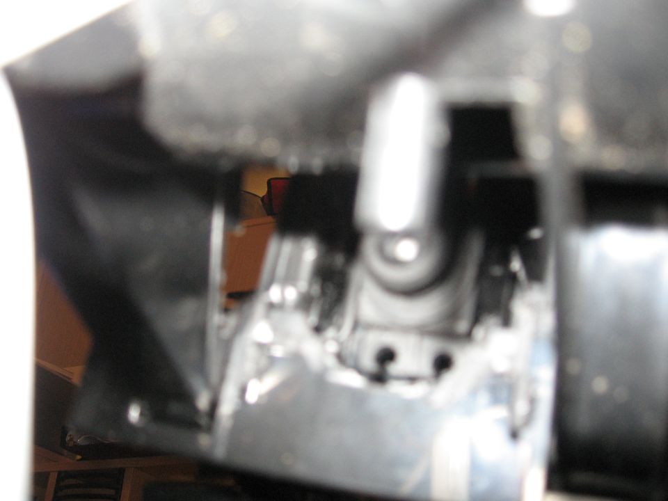 Close-up of a shiny metal component with black plastic trim and visible bolts