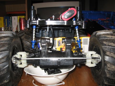 1990 Ford Bronco - Close-up of a remote control monster truck chassis, showing suspension and large tires.