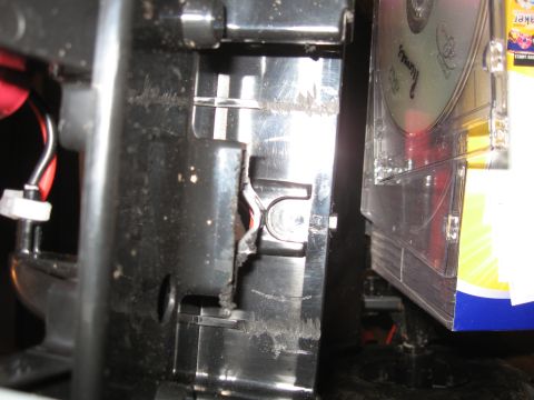 1990 Ford Bronco - Damaged plastic housing with wires visible, next to a stack of CDs.